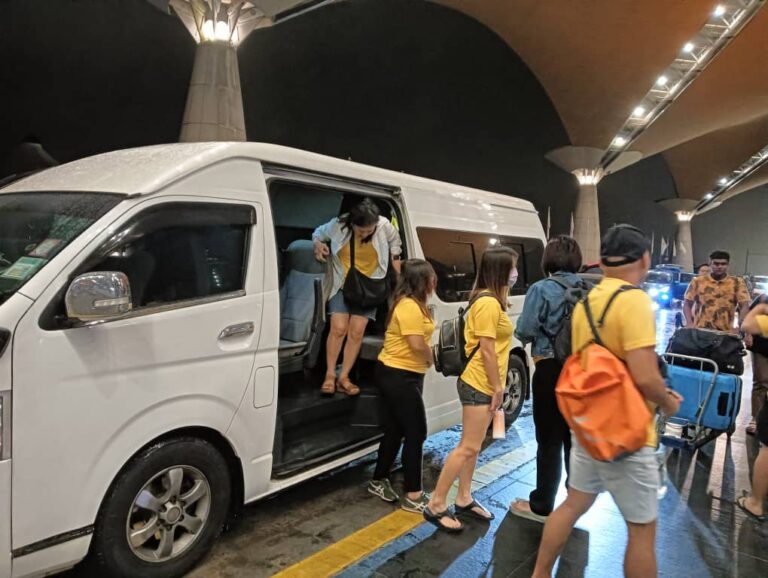 Van dropping off passengers at KLIA – group airport transfer with driver.